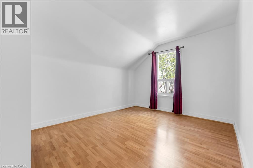 Bright room featuring wood-finish flooring, white walls, and a window with natural light - 168 Britannia Avenue, Hamilton, ON - Indoor Photo Showing Other Room