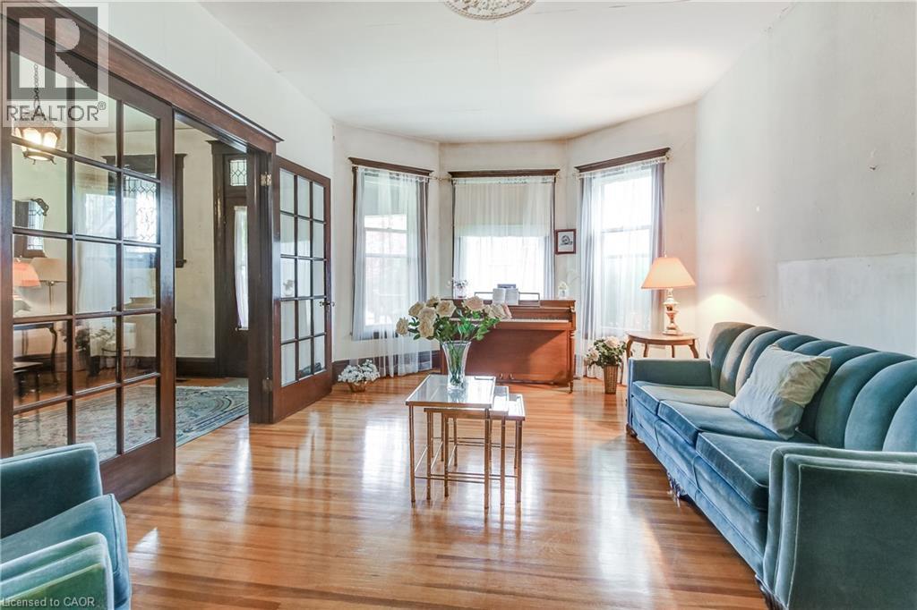 Spacious living area featuring polished wood-finish flooring and architectural bay windows - 18 Fairleigh Crescent, Hamilton, ON - Indoor Photo Showing Living Room