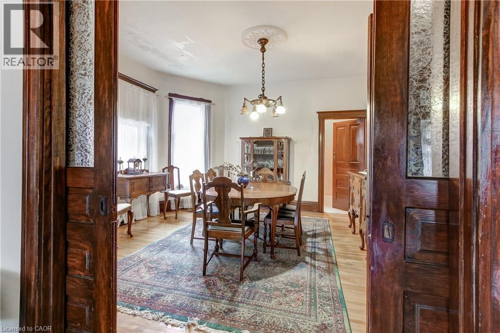 Formal dining area featuring hardwood flooring, an ornate ceiling medallion, and a chandelier with glass shades - 18 Fairleigh Crescent, Hamilton, ON - Indoor Photo Showing Dining Room