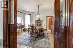 Formal dining area featuring hardwood flooring, an ornate ceiling medallion, and a chandelier with glass shades -