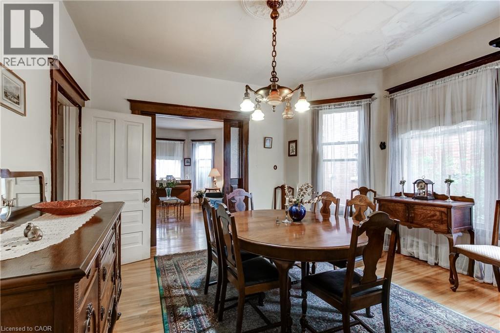 Hardwood flooring extends throughout this room, featuring ornate trim work and architectural doorways - 18 Fairleigh Crescent, Hamilton, ON - Indoor Photo Showing Dining Room