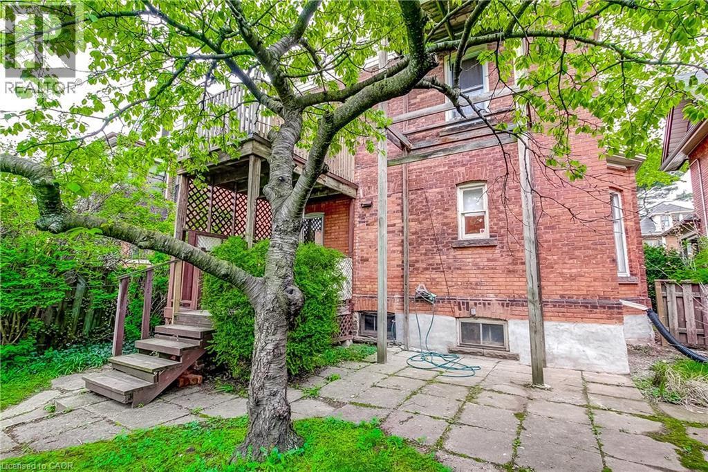 Brick exterior featuring a multi-level deck with wood stairs and lattice screening - 18 Fairleigh Crescent, Hamilton, ON - Outdoor
