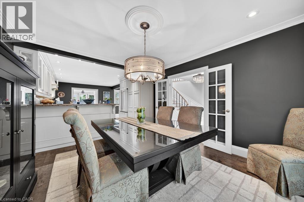Formal dining area featuring a dark wood-finish table, a decorative chandelier, and crown molding - 25 Braemar Place, Hamilton, ON - Indoor Photo Showing Dining Room