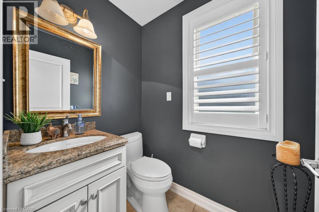 Bathroom featuring a white vanity with paneling, a stone countertop, and an undermount sink - 25 Braemar Place, Hamilton, ON - Indoor Photo Showing Bathroom