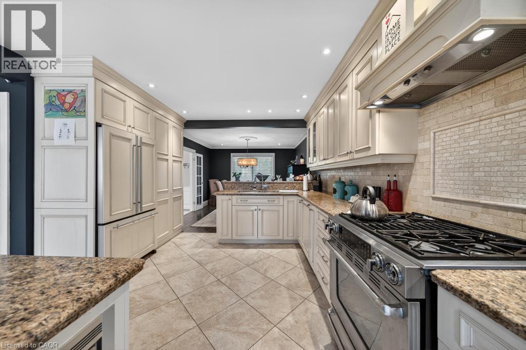 Gourmet kitchen featuring extensive cabinetry, granite countertops, and a professional-grade stainless steel range with overhead hood - 25 Braemar Place, Hamilton, ON - Indoor Photo Showing Kitchen With Upgraded Kitchen