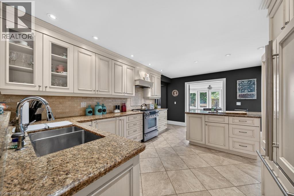 Kitchen featuring light-toned cabinetry, granite countertops, a double-basin stainless steel sink with a gooseneck faucet, a tile backsplash, and recessed lighting - 25 Braemar Place, Hamilton, ON - Indoor Photo Showing Kitchen With Double Sink With Upgraded Kitchen