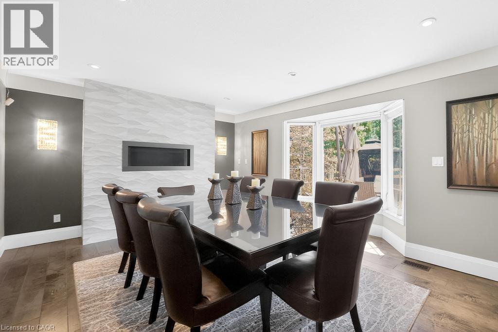 Recessed linear GAS fireplace set within a textured accent wall - 25 Braemar Place, Hamilton, ON - Indoor Photo Showing Dining Room With Fireplace