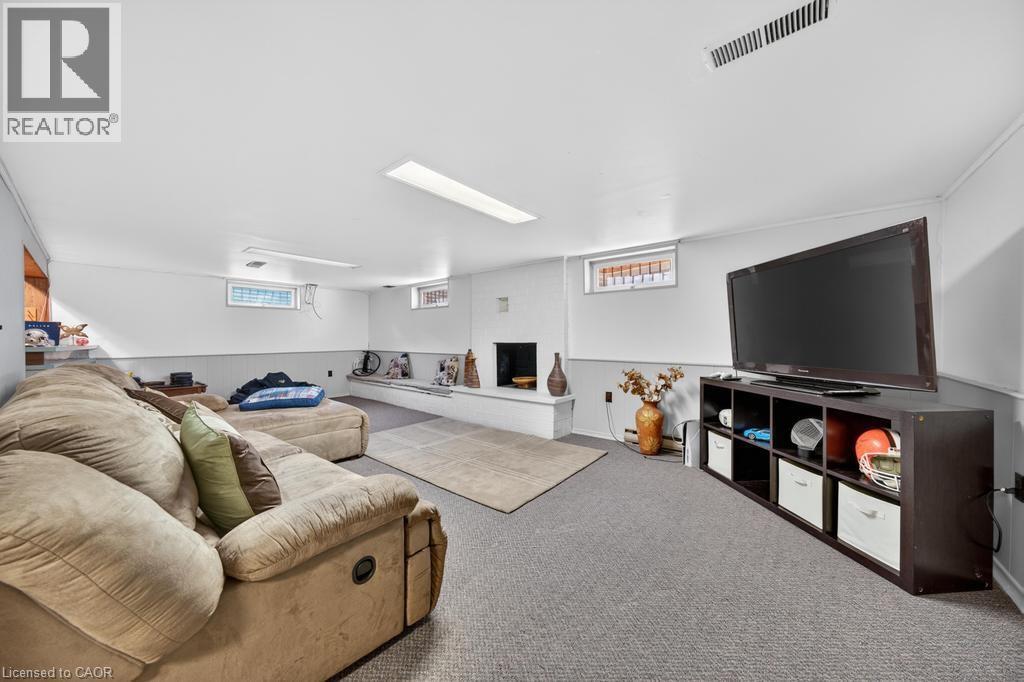 Finished basement space featuring recessed lighting, a built-in bench, carpet flooring, and white walls with a gray wainscoting detail - 25 Braemar Place, Hamilton, ON - Indoor