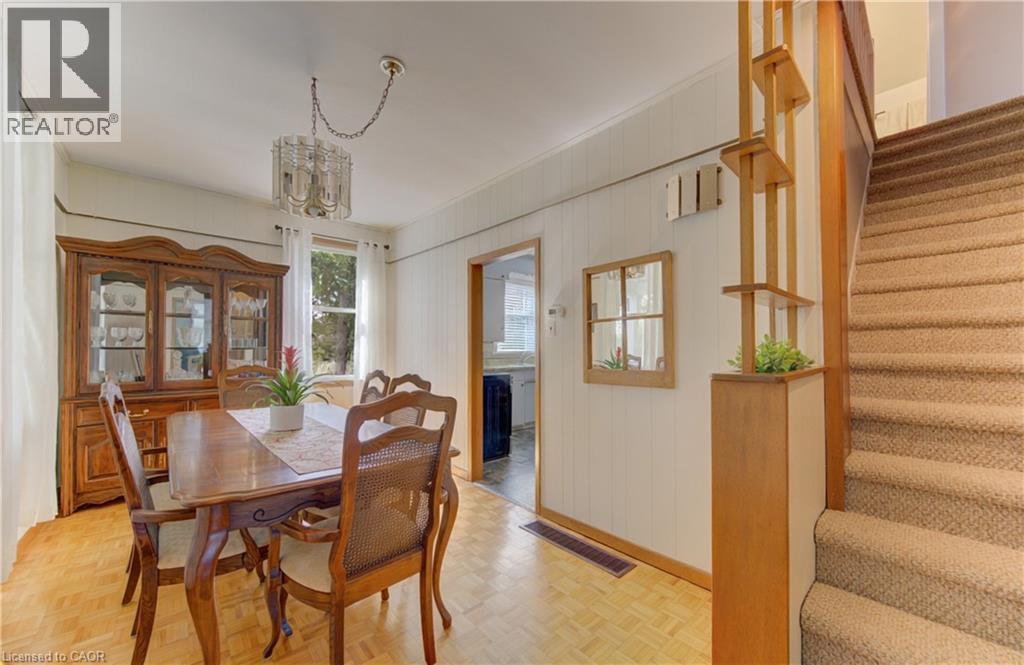 Dining area featuring wood-finish flooring, a contemporary chandelier, and a window providing natural light - 1463 Kossuth Road, Cambridge, ON - Indoor Photo Showing Dining Room