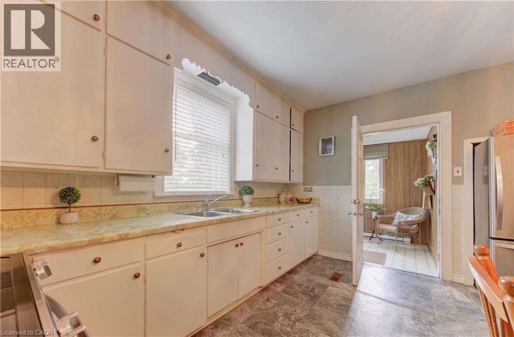 Kitchen featuring white cabinetry, a double basin stainless steel sink, and a light-toned countertop - 1463 Kossuth Road, Cambridge, ON - Indoor Photo Showing Kitchen With Double Sink