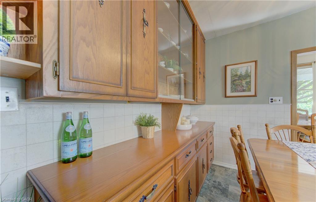 Kitchen featuring wood cabinetry with glass-front uppers, ample countertop space, and a white tiled backsplash - 1463 Kossuth Road, Cambridge, ON - Indoor Photo Showing Dining Room