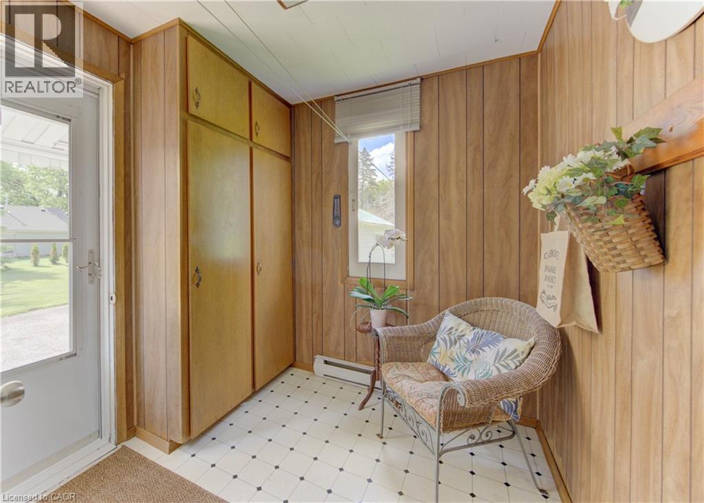 Entryway featuring wood paneling, built-in cabinetry, tiled flooring, and a window with blinds - 1463 Kossuth Road, Cambridge, ON - Indoor Photo Showing Other Room