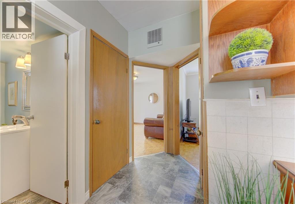 Interior hallway featuring wood-finish doors, a built-in wood-finish shelving unit, and grey-toned floor tile - 1463 Kossuth Road, Cambridge, ON - Indoor Photo Showing Other Room