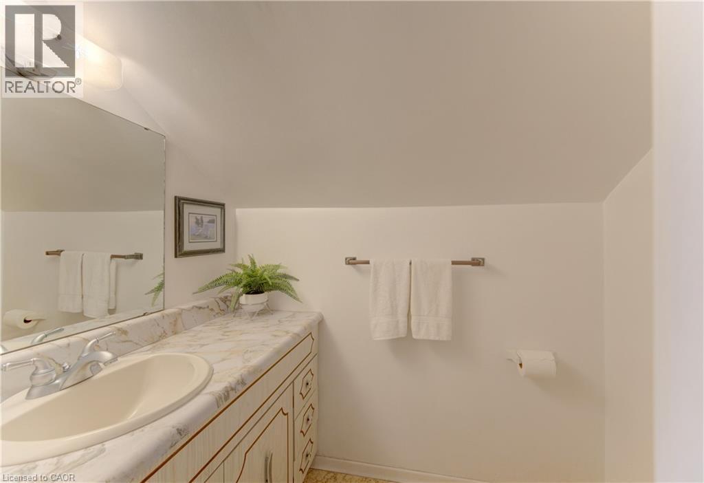 Bathroom vanity featuring a built-in sink, decorative base cabinetry, and a spacious countertop - 1463 Kossuth Road, Cambridge, ON - Indoor Photo Showing Bathroom