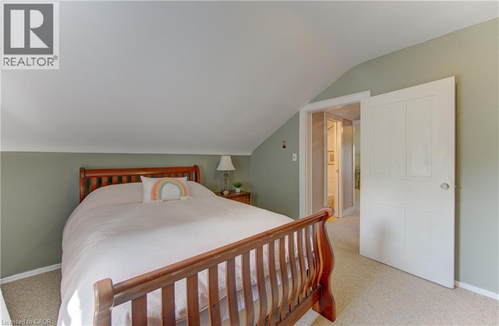 Carpeted bedroom featuring a sloped ceiling and a paneled white door - 1463 Kossuth Road, Cambridge, ON - Indoor Photo Showing Bedroom