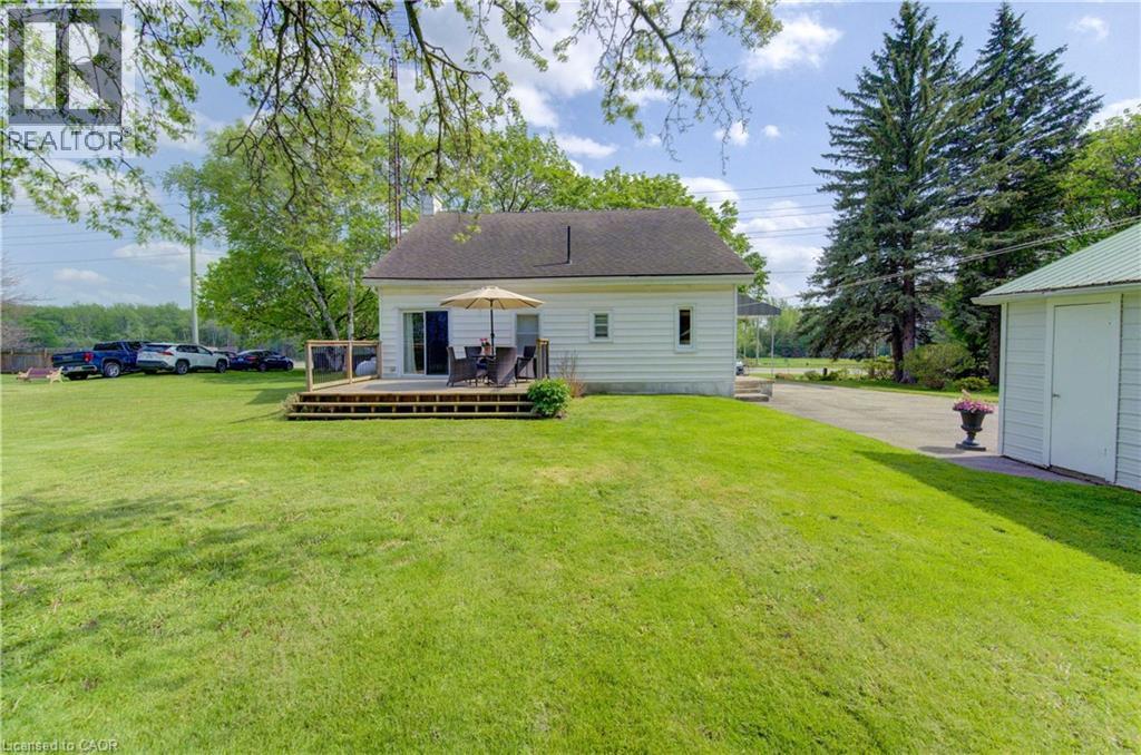 Spacious green lawn surrounding a white-sided residence with a dark roof - 1463 Kossuth Road, Cambridge, ON - Outdoor