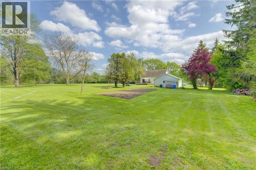 Expansive green lawn with mature trees and a dedicated garden plot - 1463 Kossuth Road, Cambridge, ON - Outdoor With View