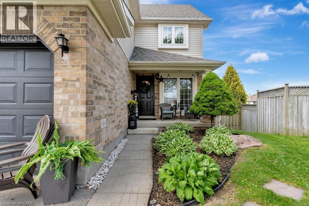 Exterior facade featuring a brick and siding construction, covered front entrance, established landscaping, a concrete pathway, and a privacy fence - 49 Small Court, Cambridge, ON - Outdoor With Deck Patio Veranda