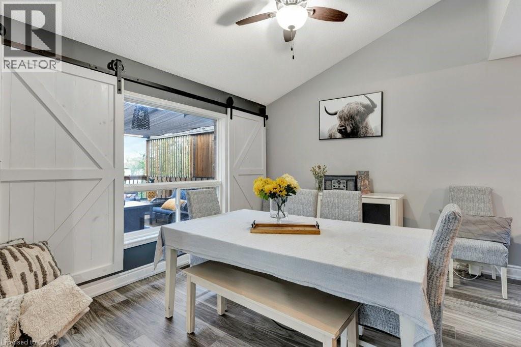Dining area featuring wood-finish flooring and a vaulted ceiling with a ceiling fan - 49 Small Court, Cambridge, ON - Indoor Photo Showing Dining Room