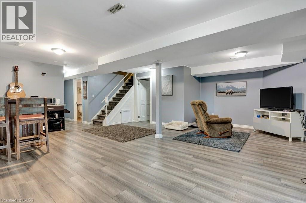 Spacious finished basement featuring wood-finish flooring and recessed lighting - 49 Small Court, Cambridge, ON - Indoor