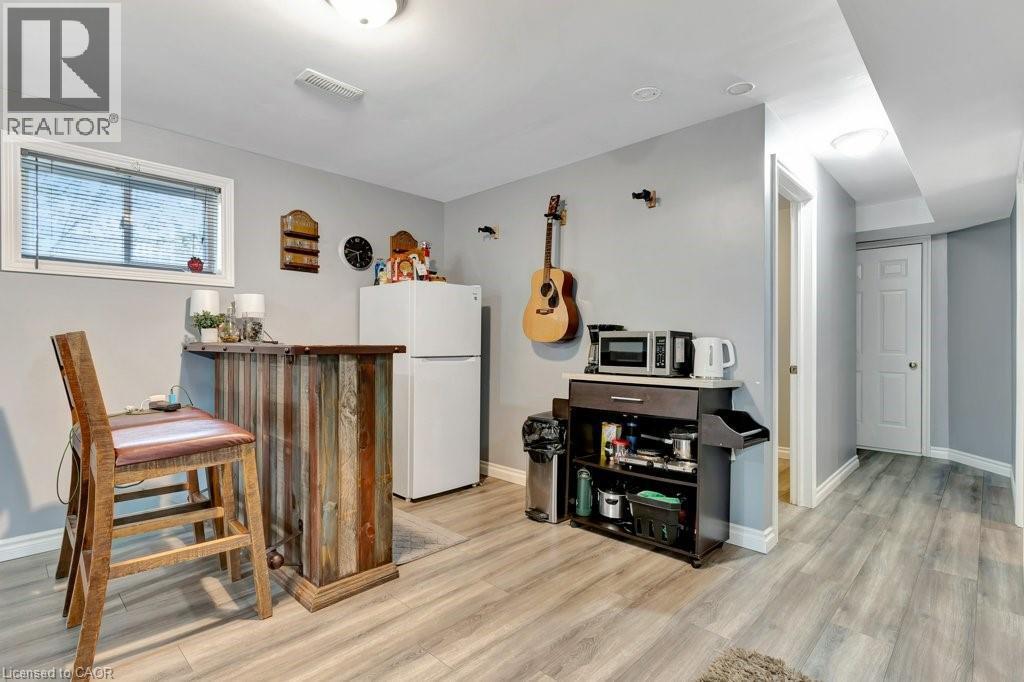 Reclaimed wood-finish bar area with built-in storage, light gray walls, and wood-finish flooring - 49 Small Court, Cambridge, ON - Indoor Photo Showing Other Room