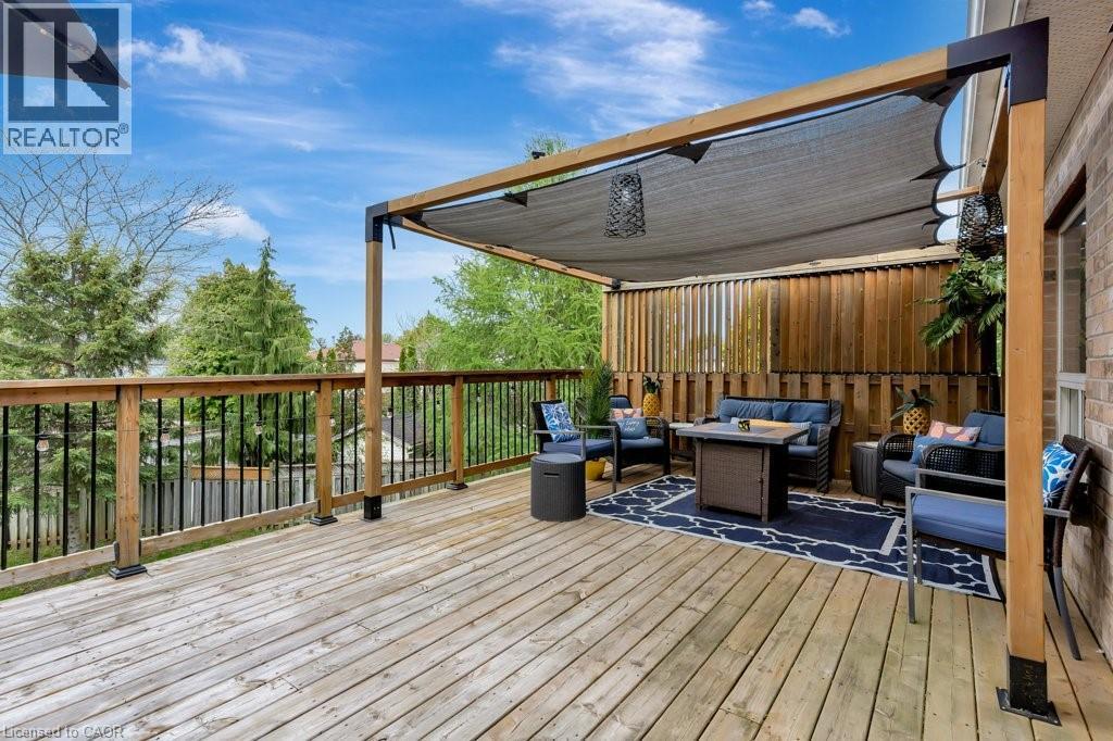 Expansive wood-plank deck featuring a pergola with a retractable shade canopy - 49 Small Court, Cambridge, ON - Outdoor With Deck Patio Veranda With Exterior