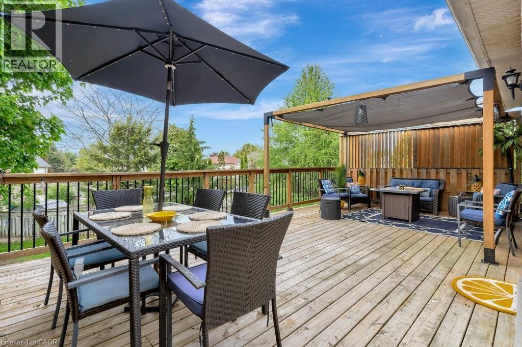 Expansive wood-finish deck featuring a dedicated dining area and a separate covered lounge space - 49 Small Court, Cambridge, ON - Outdoor With Deck Patio Veranda With Exterior