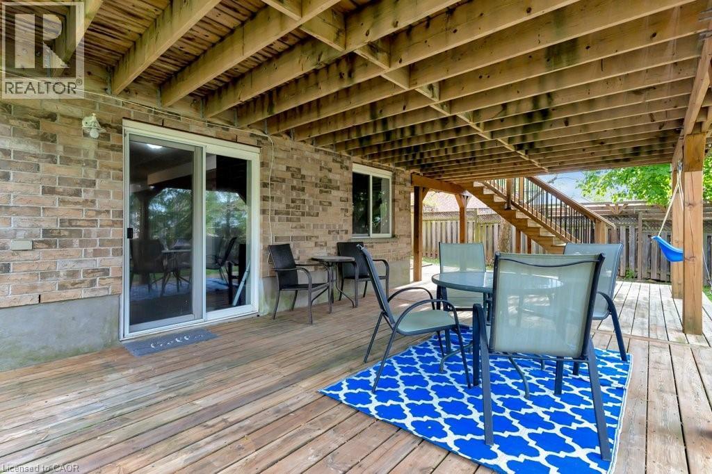 Ground-level wood-finish deck with a full brick exterior, offering a covered outdoor area - 49 Small Court, Cambridge, ON - Outdoor With Deck Patio Veranda With Exterior