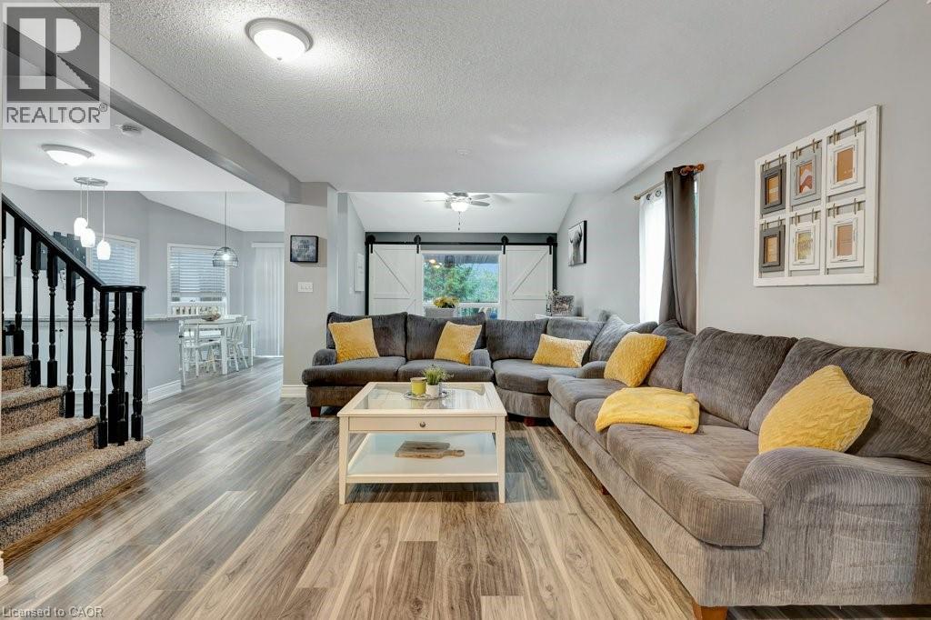 Spacious living area featuring wood-finish flooring, light grey walls, and recessed lighting - 49 Small Court, Cambridge, ON - Indoor Photo Showing Living Room