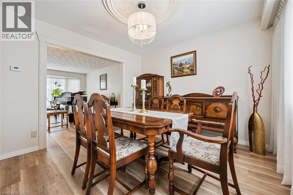 Formal dining area featuring wood-finish flooring, a decorative ceiling medallion, and a chandelier light fixture - 488 Heather Hill Place, Waterloo, ON - Indoor Photo Showing Dining Room