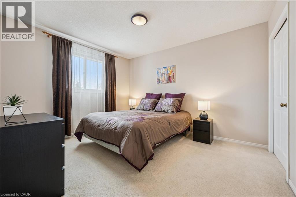 Neutral-toned bedroom featuring a window with natural light, wall-to-wall carpeting, and a flush-mount ceiling light fixture - 488 Heather Hill Place, Waterloo, ON - Indoor Photo Showing Bedroom