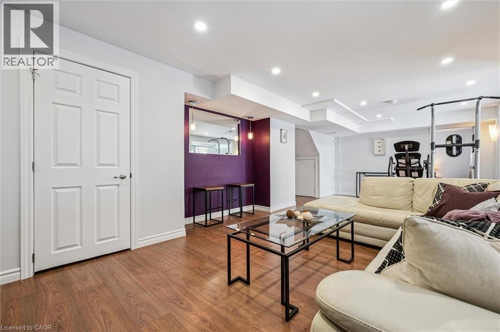 Recessed lighting illuminates this versatile space featuring wood-finish flooring - 488 Heather Hill Place, Waterloo, ON - Indoor Photo Showing Living Room