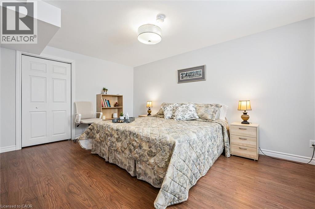 Room featuring wood-finish flooring, white walls, and a recessed bi-fold closet - 488 Heather Hill Place, Waterloo, ON - Indoor Photo Showing Bedroom