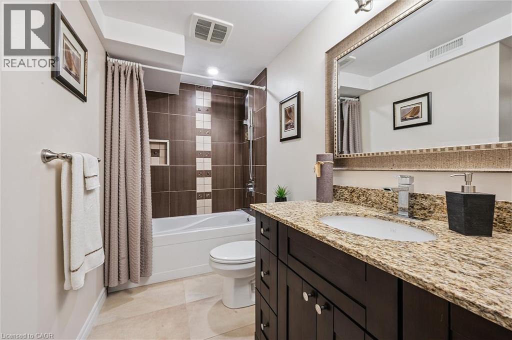 Bathroom featuring a dark wood vanity with a light granite countertop, an undermount sink, and a large framed mirror - 488 Heather Hill Place, Waterloo, ON - Indoor Photo Showing Bathroom