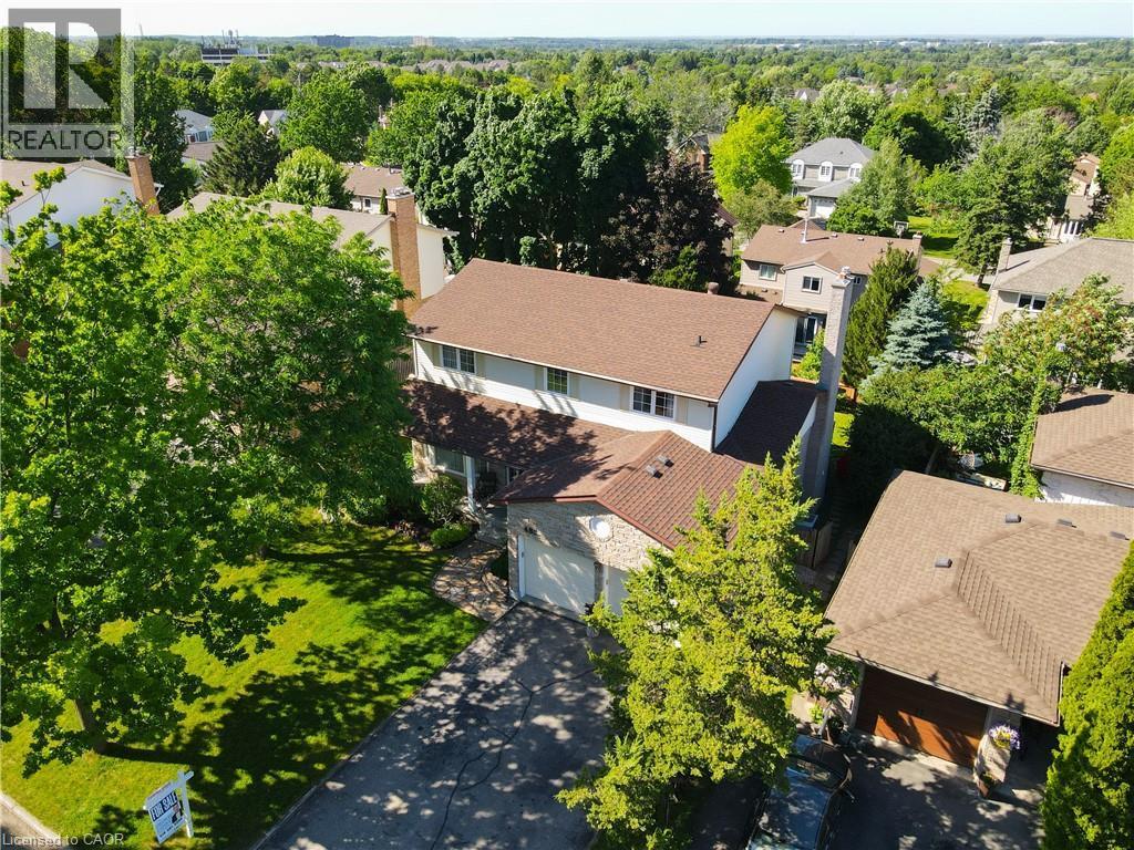 Residential property featuring a two-story structure with a brown shingle roof, attached garage, and a paved driveway - 488 Heather Hill Place, Waterloo, ON - Outdoor