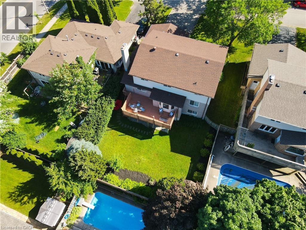 Expansive backyard featuring a manicured lawn, mature trees, and a multi-level wood-finish deck - 488 Heather Hill Place, Waterloo, ON - Outdoor With Deck Patio Veranda