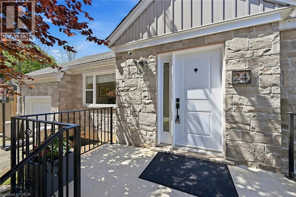 Stone veneer facade with a white paneled entry door, sidelight, and wrought iron railing - 24 Glenwood Crescent, Hamilton, ON - Outdoor With Exterior