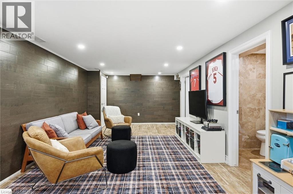 Recreation room featuring recessed lighting, paneled accent walls, light-toned flooring, and a doorway to a tiled bathroom - 24 Glenwood Crescent, Hamilton, ON - Indoor Photo Showing Other Room