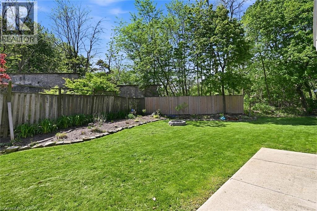 Expansive green lawn with a concrete patio - 24 Glenwood Crescent, Hamilton, ON - Outdoor With Backyard