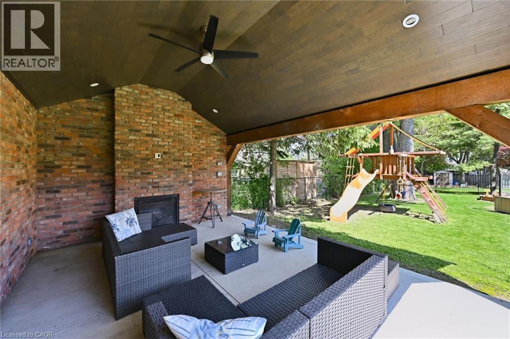 Covered patio featuring a brick fireplace, ceiling fan, recessed lighting, and a solid wood beam structure - 24 Glenwood Crescent, Hamilton, ON - Outdoor