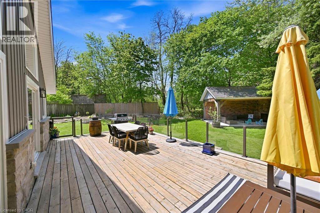 Expansive wood deck with glass panel railing overlooking a spacious lawn - 24 Glenwood Crescent, Hamilton, ON - Outdoor With Deck Patio Veranda