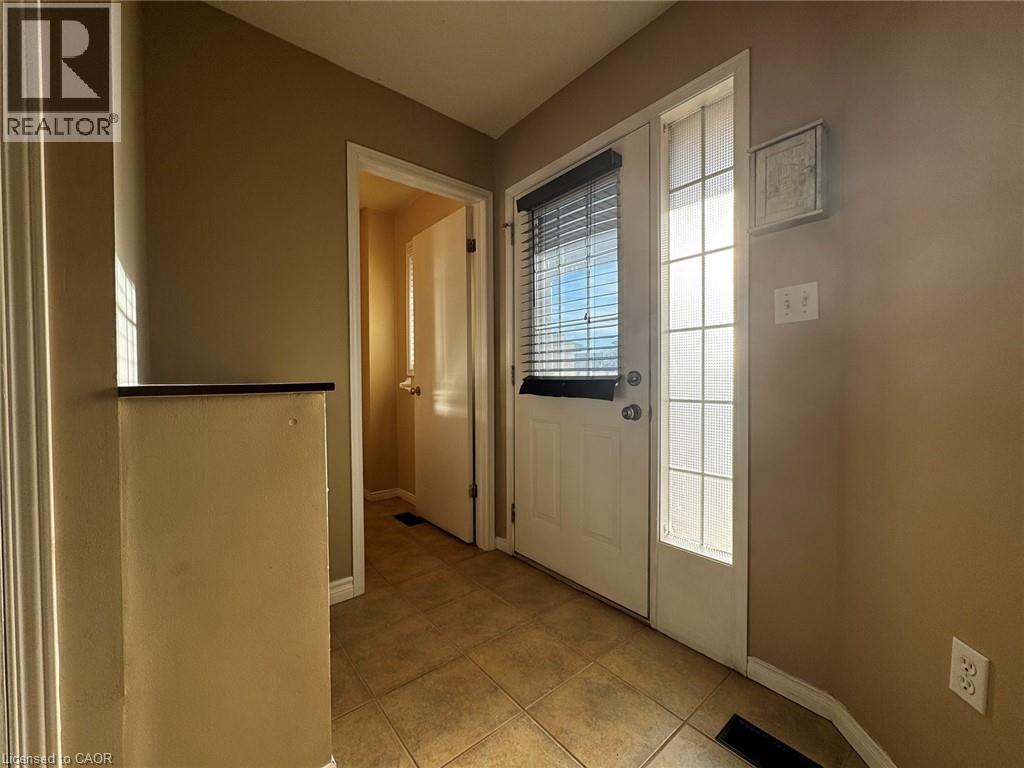 Entryway featuring tile flooring, a white door with an integrated window blind, and an adjacent sidelight window - 37 Northcliffe Crescent, Cambridge, ON - Indoor Photo Showing Other Room