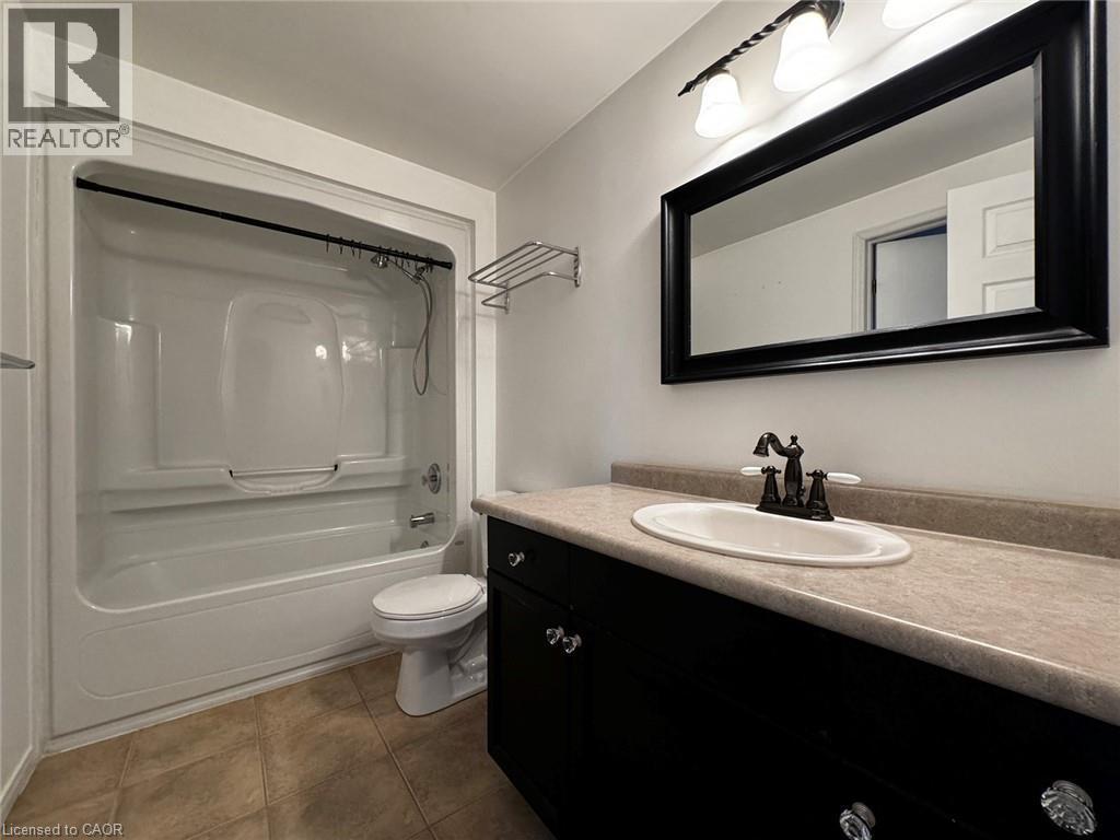 Bathroom featuring a dark wood-finish vanity with a light countertop, an undermount sink, and a framed mirror - 37 Northcliffe Crescent, Cambridge, ON - Indoor Photo Showing Bathroom