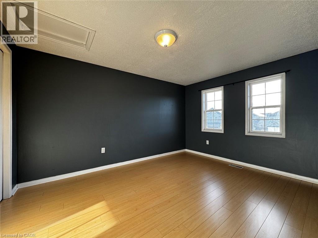 Room featuring wood-finish flooring, two sash windows, and dark wall paint - 37 Northcliffe Crescent, Cambridge, ON - Indoor Photo Showing Other Room