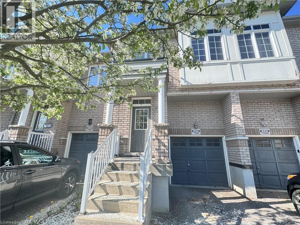 Brick facade townhome with covered porch entry, white railing, and multi-pane windows - 110 Highland Road E Unit# 53, Kitchener, ON - Outdoor