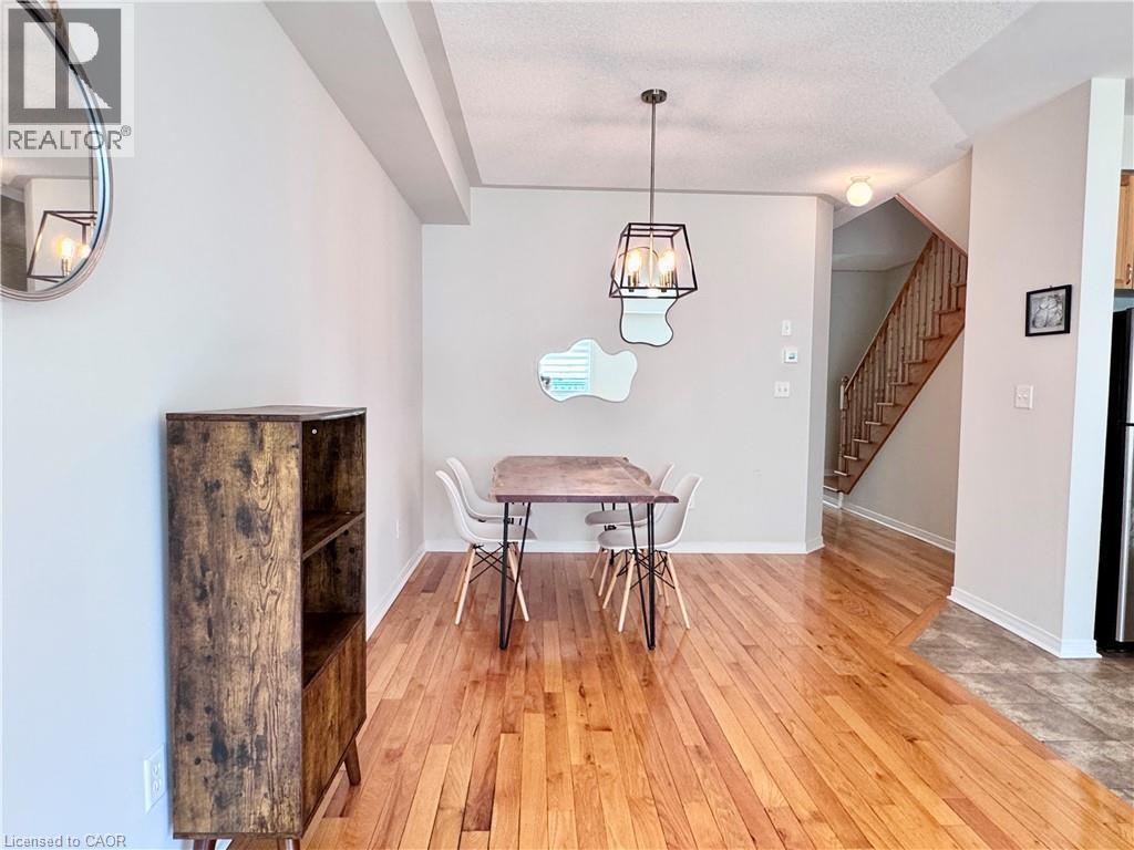 Hardwood-style flooring throughout a spacious room featuring a contemporary chandelier - 110 Highland Road E Unit# 53, Kitchener, ON - Indoor