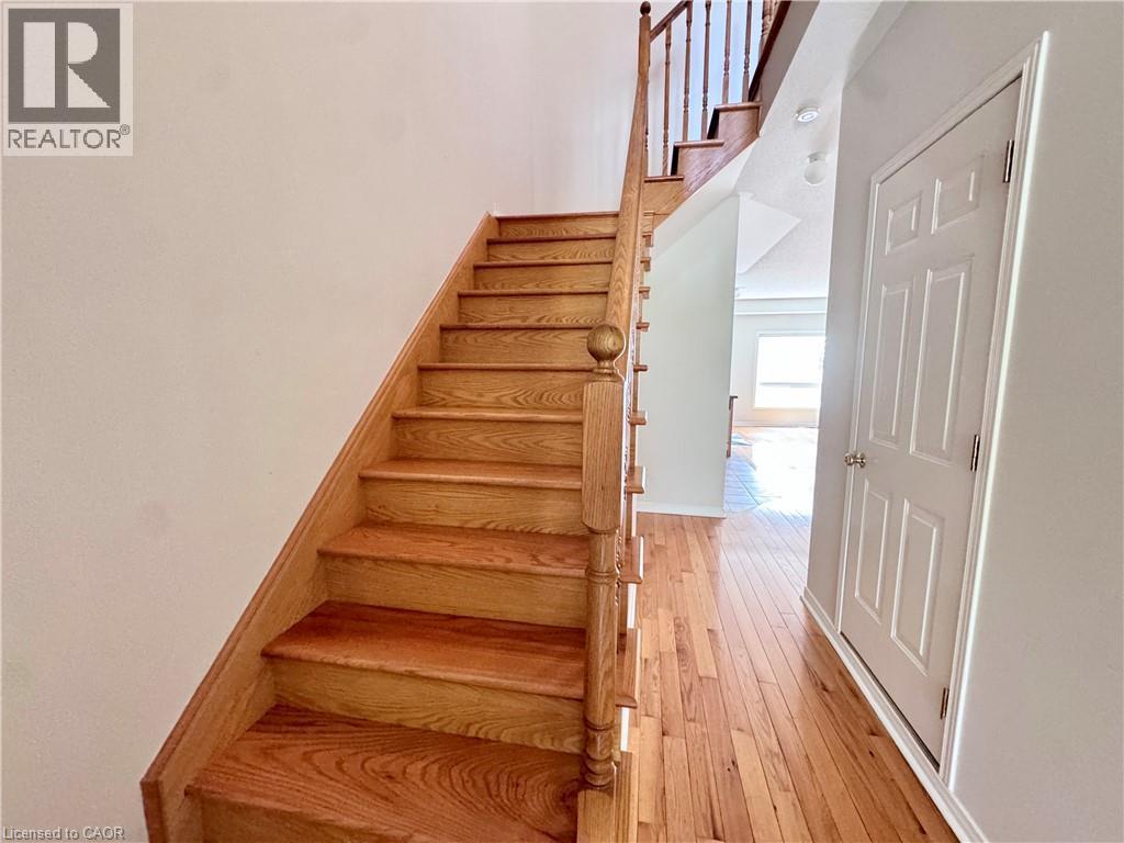 Hardwood staircase featuring a natural wood finish, leading to an upper level - 110 Highland Road E Unit# 53, Kitchener, ON - Indoor Photo Showing Other Room