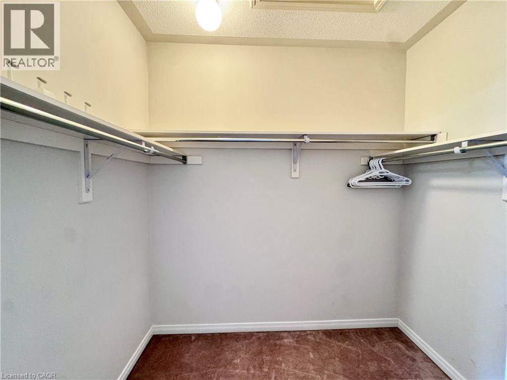 Walk-in closet with integrated shelving and hanging rods - 110 Highland Road E Unit# 53, Kitchener, ON - Indoor With Storage