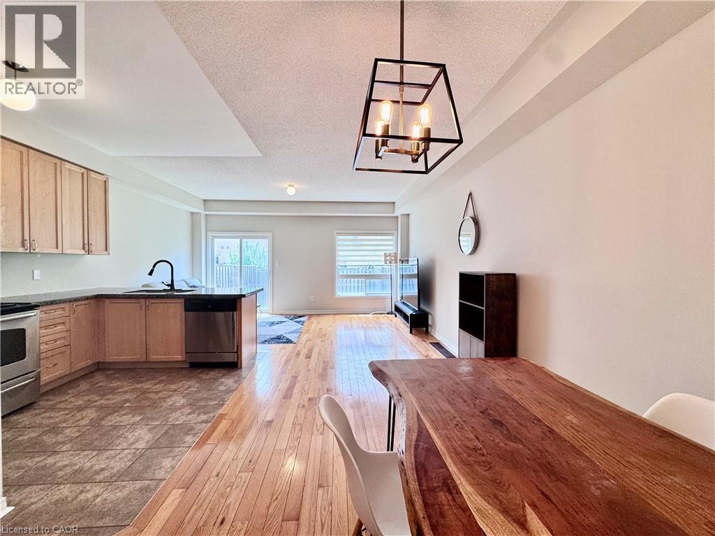 Open-concept living space with wood-finish flooring extending into the dining area - 110 Highland Road E Unit# 53, Kitchener, ON - Indoor Photo Showing Kitchen