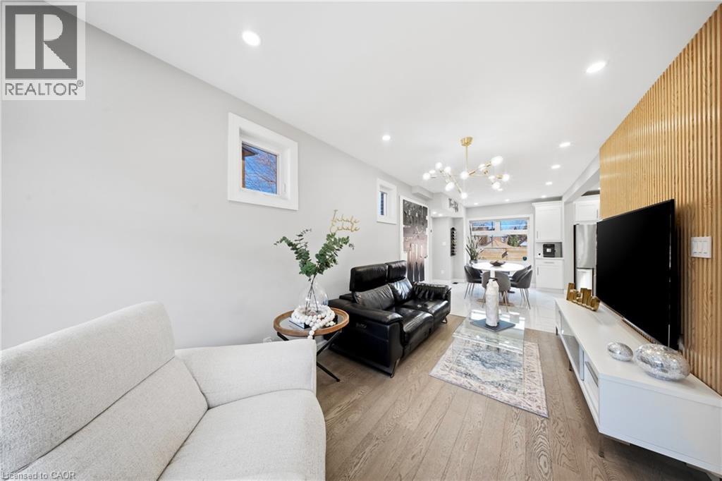 Living room featuring light wood finished floors and suspended lighting - 273 Stinson Crescent, Hamilton, ON - Indoor Photo Showing Living Room